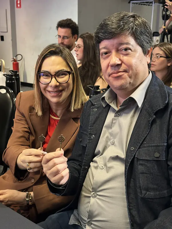 Casal sorrindo lado a lado com suas chaves