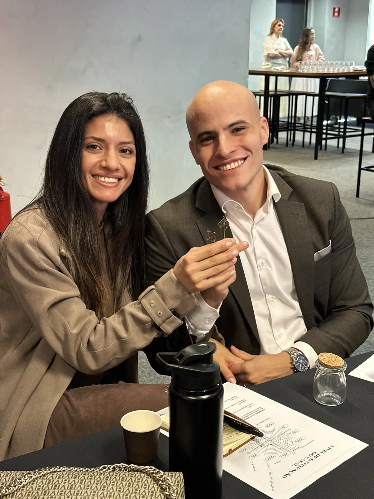 Casal sentado lado a lado, unindo as mãos com suas chaves